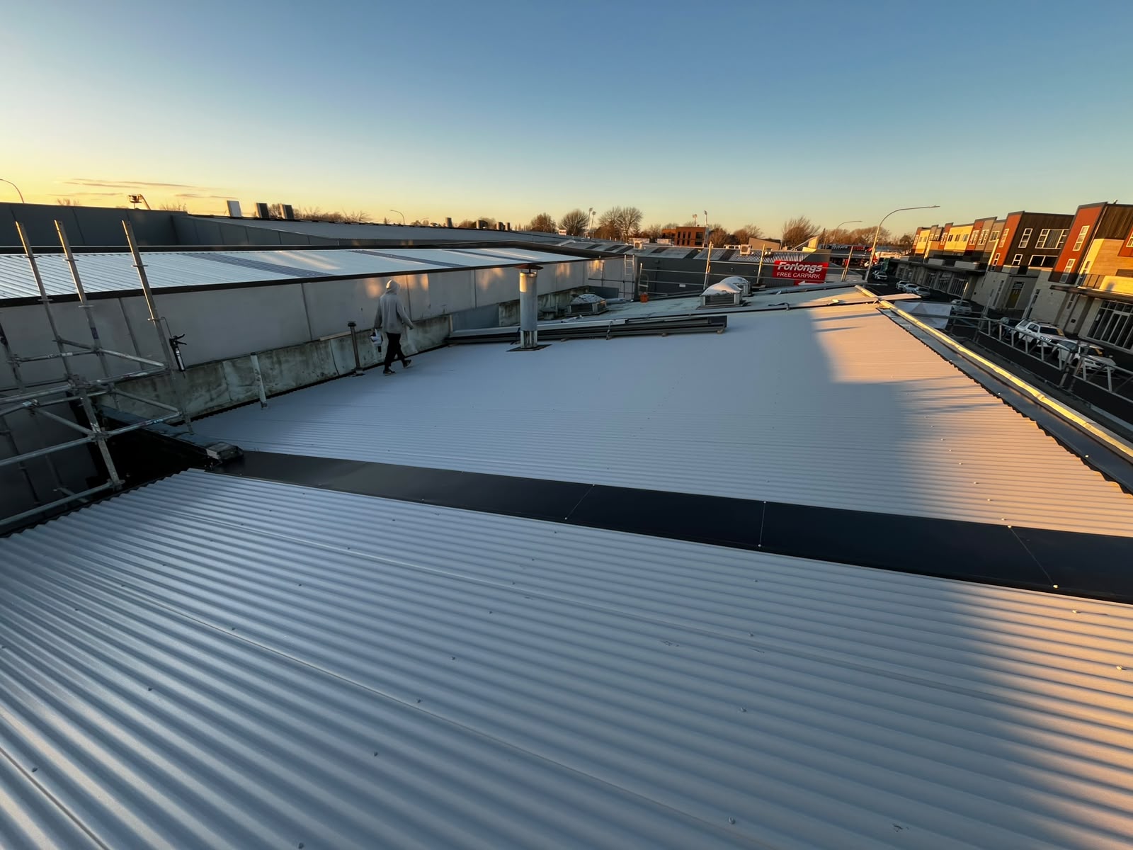 Completed long-run commercial roof at sunset